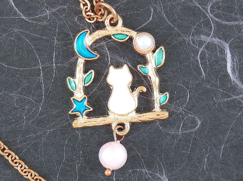 modern necklaces for women -17-inch necklace with tiny enamelled white cat sitting on a branch, blue moon and star, pearl detail, rose gold-toned stainless steel chain